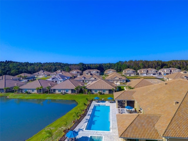 outdoor pool featuring a water view and a residential view