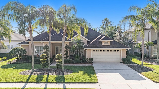 view of front of house featuring an attached garage, driveway, a front lawn, and stucco siding