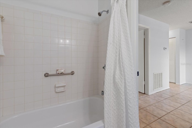 full bath with a textured ceiling, tile patterned flooring, visible vents, and shower / bathtub combination with curtain