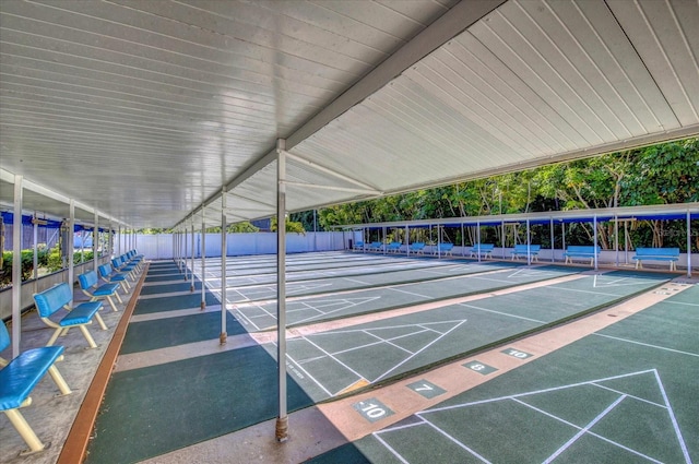 view of community with shuffleboard and fence