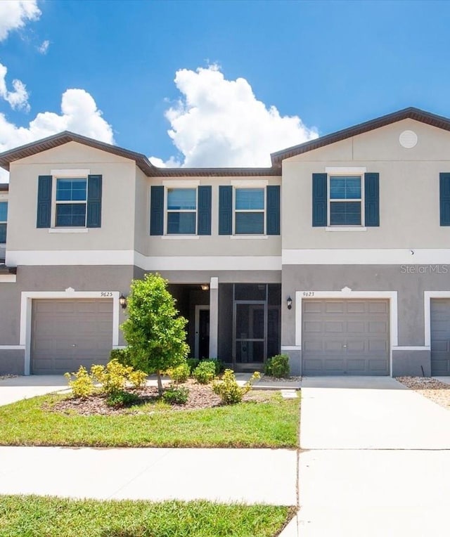 view of property featuring driveway, an attached garage, and stucco siding