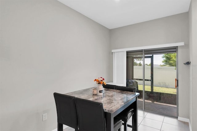 dining space with light tile patterned floors and baseboards