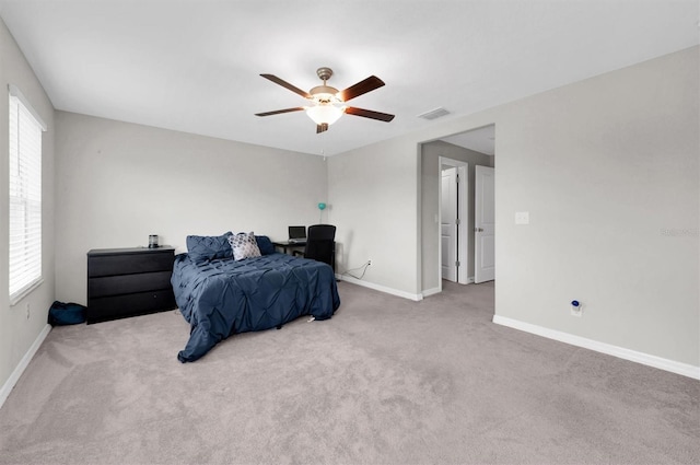 carpeted bedroom with a ceiling fan, visible vents, and baseboards