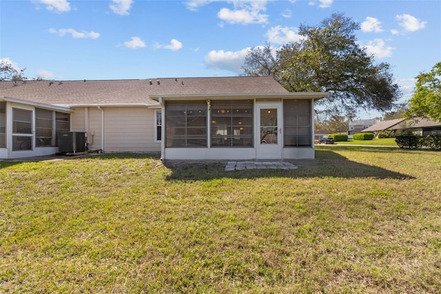 rear view of house featuring a sunroom, central AC unit, and a lawn