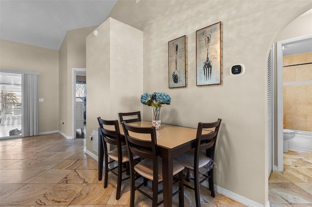 dining room featuring stone tile flooring and baseboards