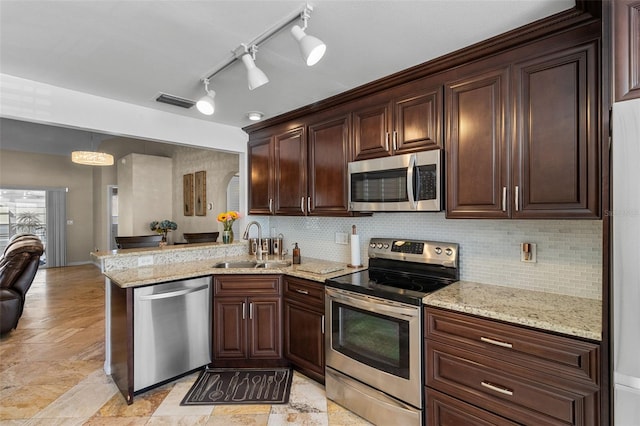 kitchen featuring visible vents, decorative backsplash, a peninsula, stainless steel appliances, and a sink