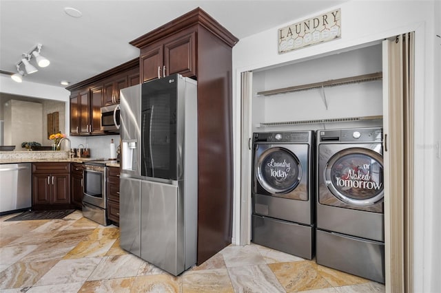 laundry area with laundry area, independent washer and dryer, and a sink