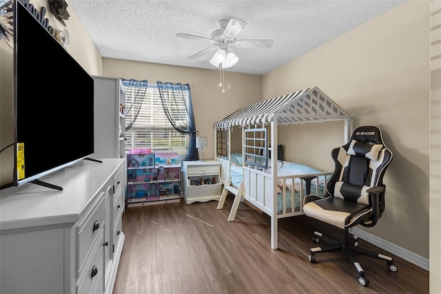 bedroom featuring dark wood-style floors, ceiling fan, baseboards, and a textured ceiling