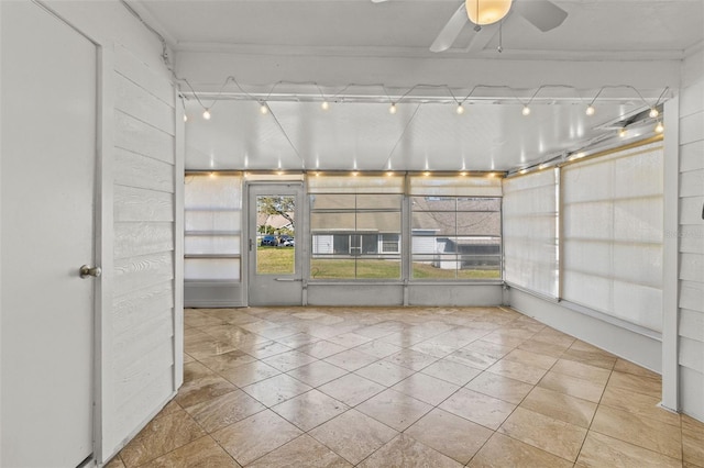 unfurnished sunroom featuring a ceiling fan