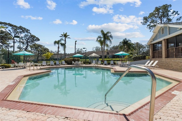 community pool featuring a patio and fence