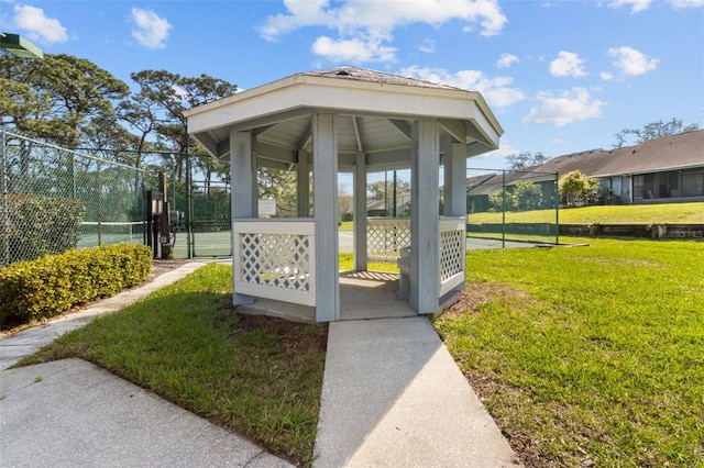 view of home's community with a gazebo, a lawn, fence, and a gate