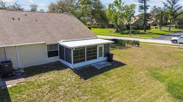 details featuring a shingled roof, cooling unit, and a downspout