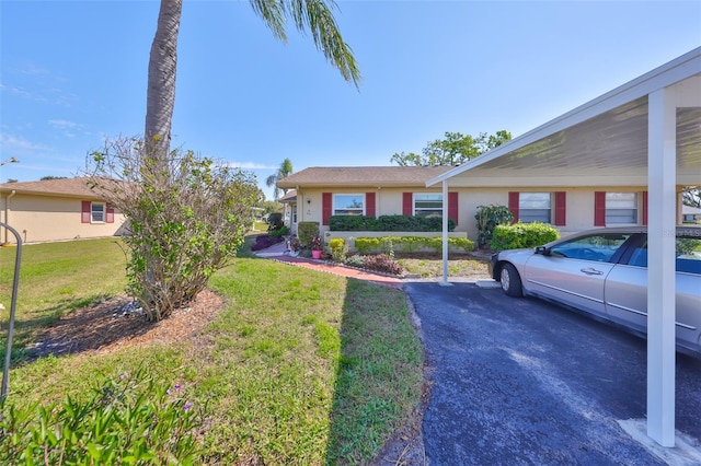 ranch-style home with a front lawn and stucco siding