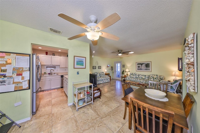 dining space featuring visible vents and a textured ceiling