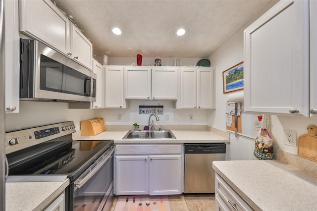 kitchen featuring recessed lighting, stainless steel appliances, light countertops, and a sink