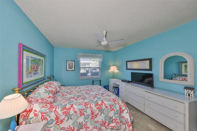 bedroom with a ceiling fan, carpet floors, and a textured ceiling