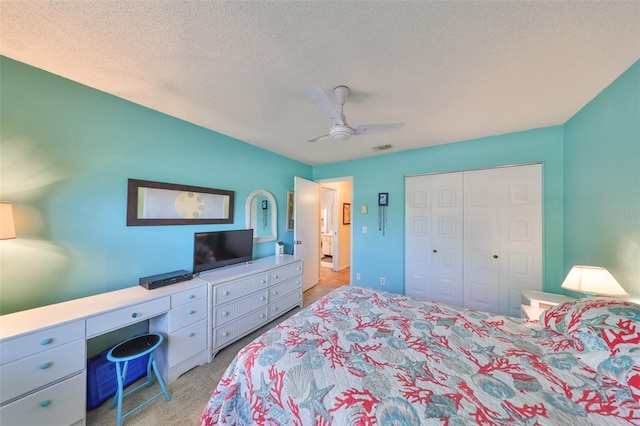 bedroom featuring a textured ceiling, a ceiling fan, visible vents, a closet, and light carpet