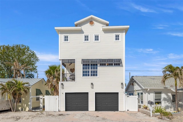 exterior space with a garage, a balcony, fence, and a gate