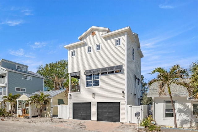 view of front of property featuring a garage, fence, and a gate