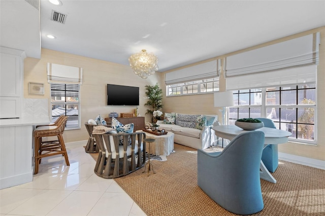 living area featuring a chandelier, light tile patterned flooring, visible vents, and a healthy amount of sunlight