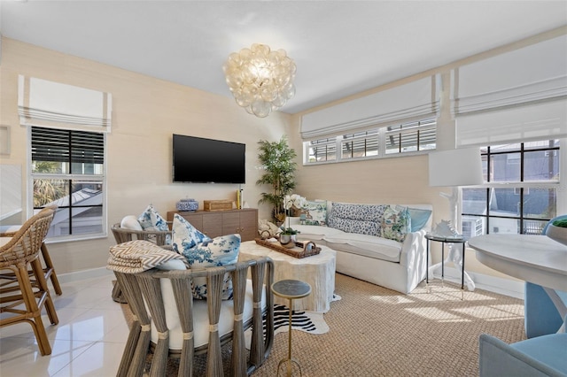 living room featuring baseboards, tile patterned flooring, and an inviting chandelier