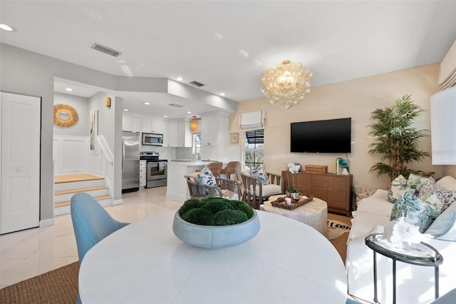 dining space featuring light tile patterned floors, a chandelier, visible vents, and stairs