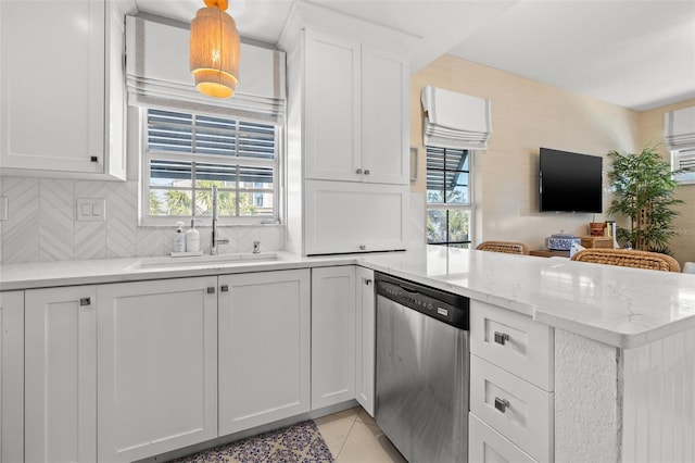 kitchen with light tile patterned floors, a wealth of natural light, white cabinetry, a sink, and dishwasher