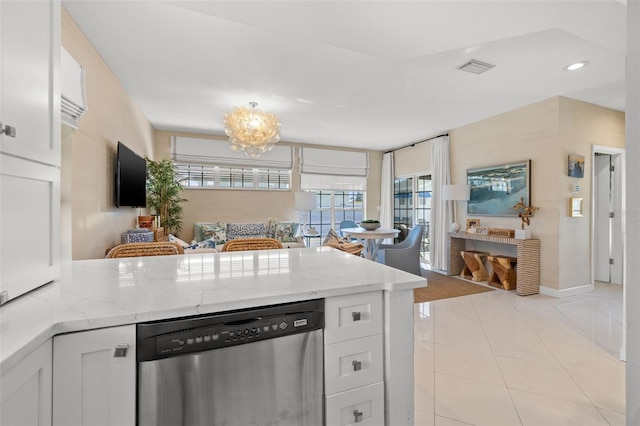 kitchen featuring light tile patterned flooring, a peninsula, white cabinetry, stainless steel dishwasher, and light stone countertops