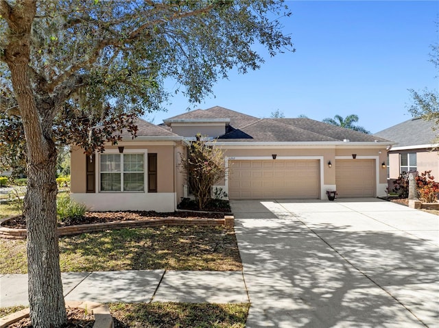 view of front of home with stucco siding, concrete driveway, an attached garage, and a shingled roof