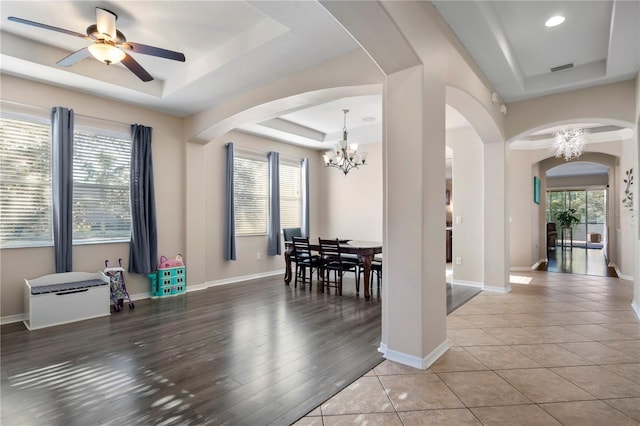 dining area featuring plenty of natural light, a tray ceiling, and baseboards