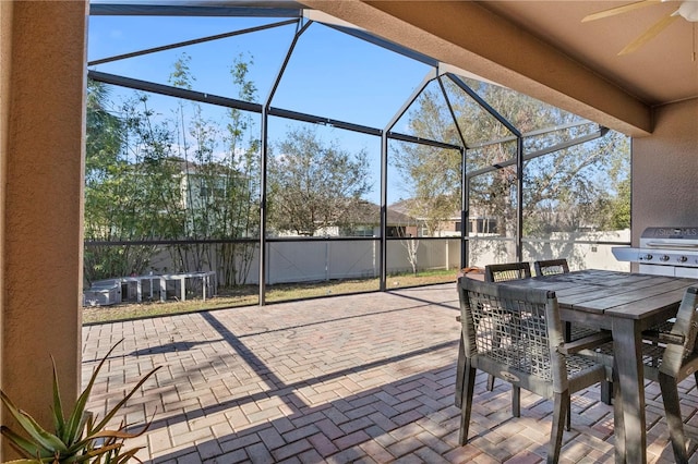 view of patio / terrace featuring ceiling fan, glass enclosure, outdoor dining space, and area for grilling