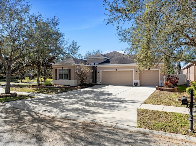 view of front of house with driveway, an attached garage, and stucco siding