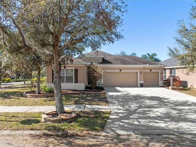 single story home featuring driveway, an attached garage, and stucco siding