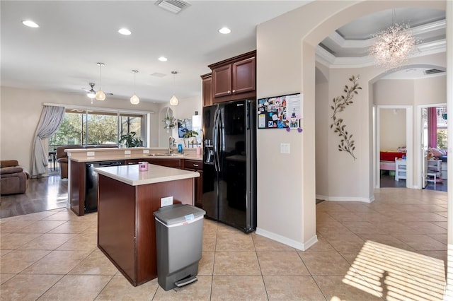 kitchen featuring dishwashing machine, a peninsula, visible vents, light countertops, and black fridge