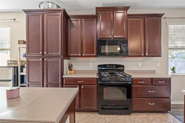 kitchen with black appliances, light countertops, and a wealth of natural light