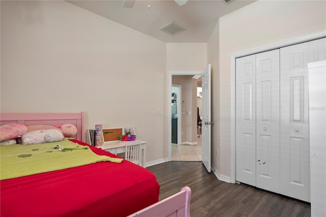 bedroom with ceiling fan, wood finished floors, visible vents, baseboards, and a closet