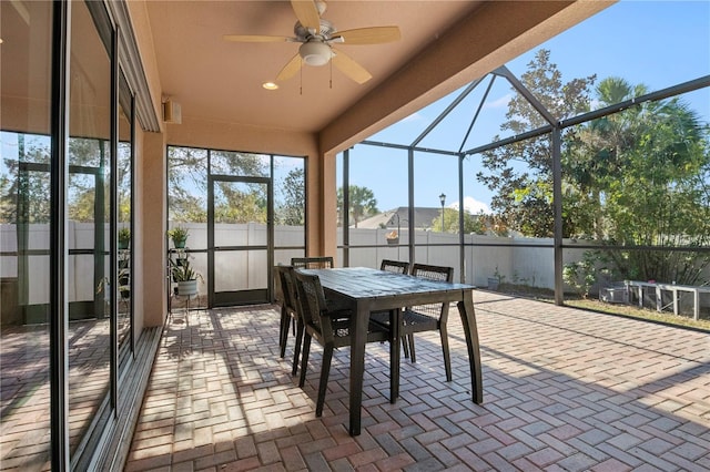 unfurnished sunroom featuring ceiling fan