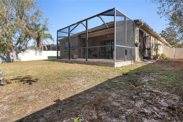 back of house featuring a yard, a fenced backyard, and glass enclosure