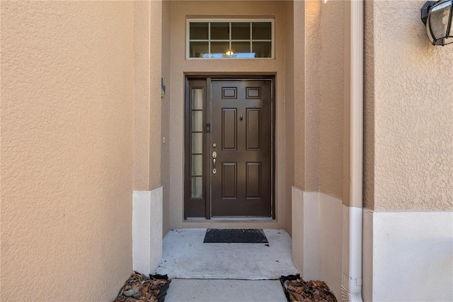 view of exterior entry featuring stucco siding