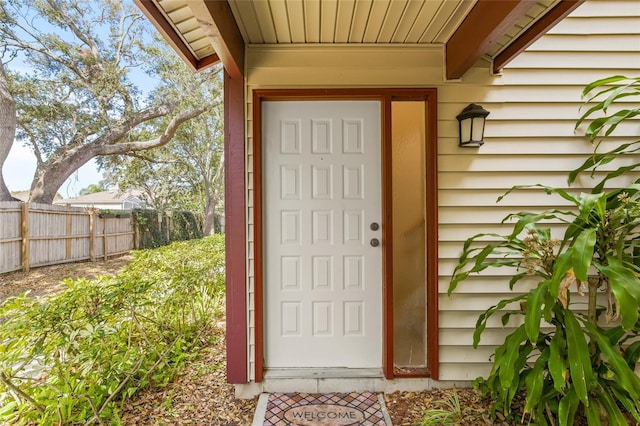 view of exterior entry featuring fence