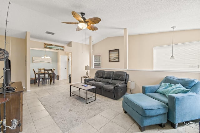 tiled living area with visible vents, vaulted ceiling, a textured ceiling, and ceiling fan