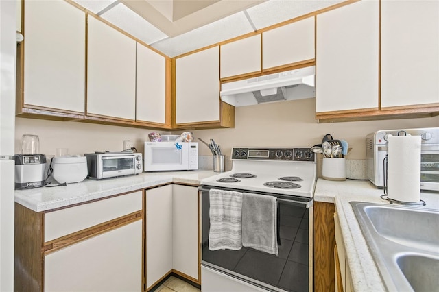 kitchen with light countertops, white appliances, white cabinets, and under cabinet range hood