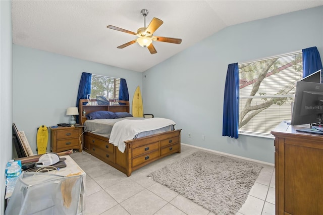 bedroom with light tile patterned flooring, vaulted ceiling, baseboards, and ceiling fan