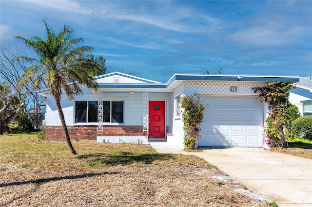 ranch-style home with a front lawn, brick siding, driveway, and an attached garage