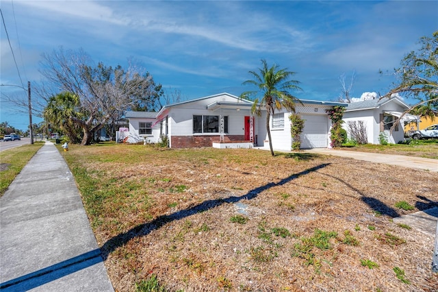 view of front of property featuring a front yard, brick siding, driveway, and an attached garage