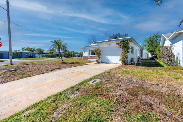 view of side of home with driveway, an attached garage, and a lawn