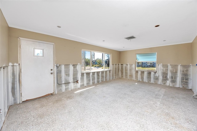 empty room featuring visible vents and crown molding