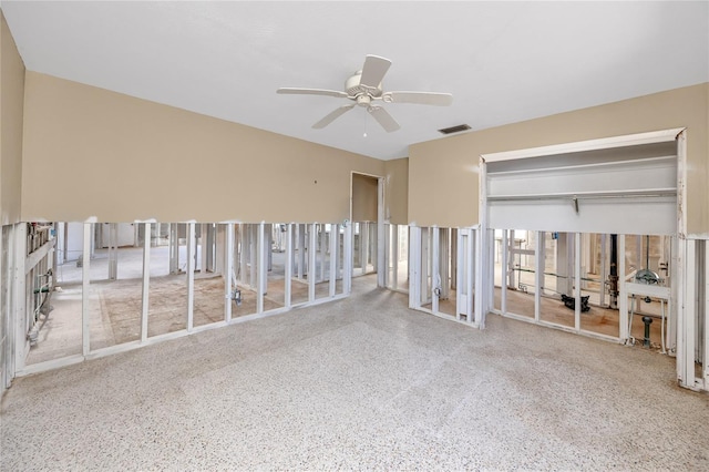 spare room featuring visible vents, ceiling fan, and speckled floor