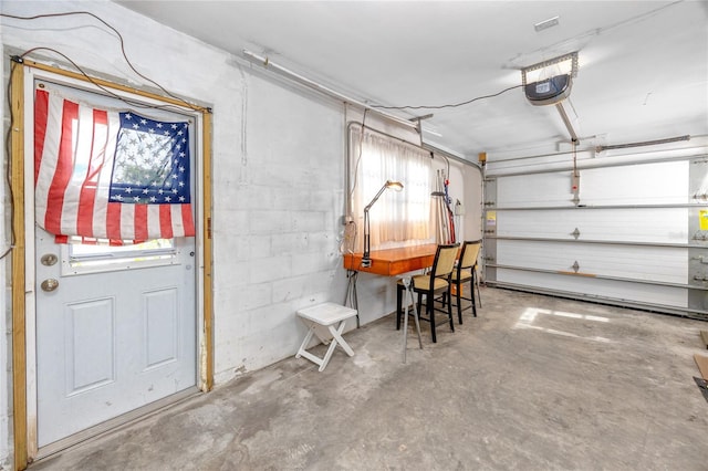 garage featuring concrete block wall and a garage door opener