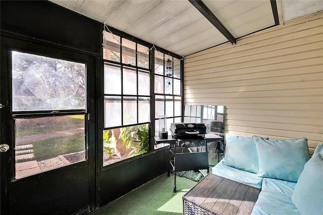 sunroom with a healthy amount of sunlight and lofted ceiling with beams